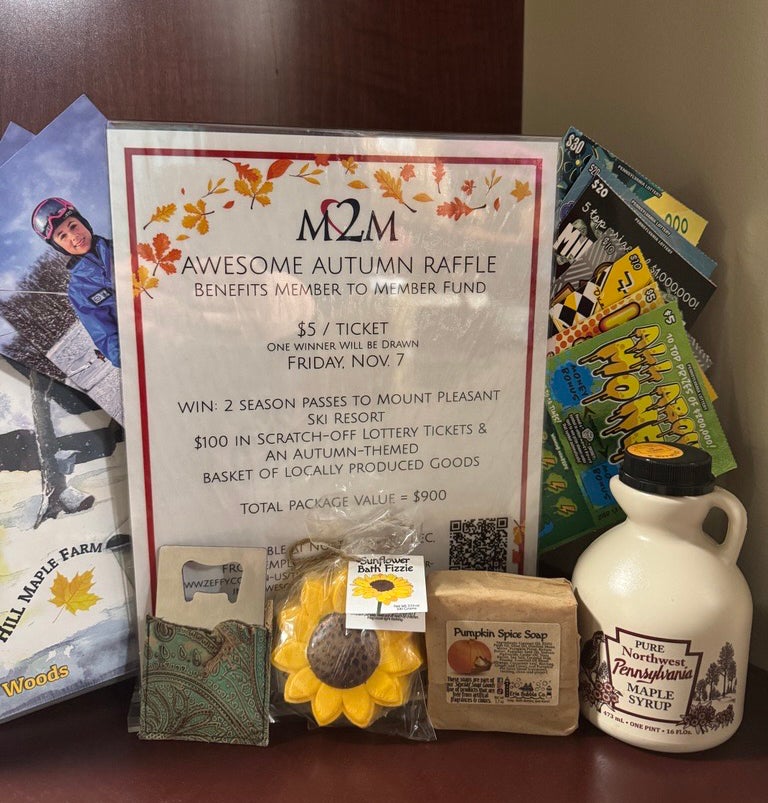 Awesome Autumn Raffle Photo shows a sign outlining the rules of the raffle (also listed in below text), lottery tickets, brochures for Mount Pleasant Ski Resort, a jug of maple syrup, a sunflower bath bomb, and hand-tooled leather bottle opener, and maple syrup recipes book, and a bar of pumpkin spice soap. 